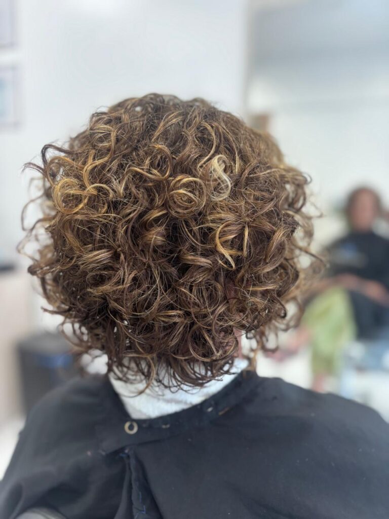 Cabelo depois do método: cachos definidos e brilhantes.